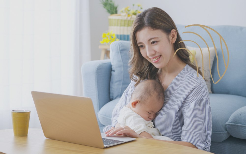 赤ちゃんを抱っこしながら抱っこのオンラインセミナーを受講しているお母さん