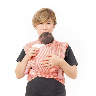 ベビーラップに赤ちゃんを抱き入れるお母さん