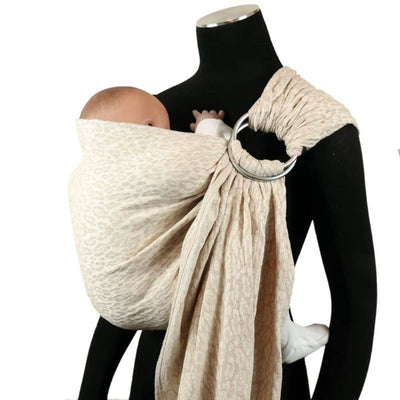 オフホワイトのヒョウ柄のスリングで赤ちゃん人形を抱っこするマネキン