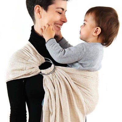 白いスリングで赤ちゃんを抱っこしている女性