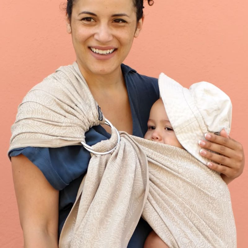 帽子をかぶった赤ちゃんを抱っこする笑顔の女性