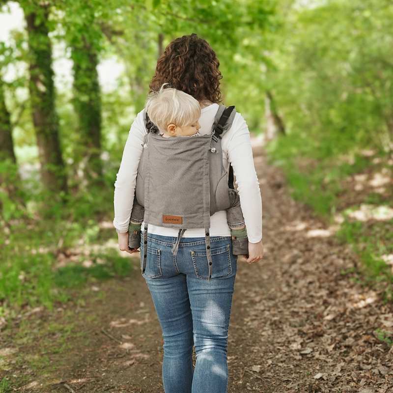 グレーのおんぶ紐でこどもをおんぶする女性