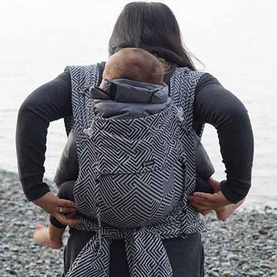 ディディモスの白黒カラーのハーフバックル式抱っこ紐で赤ちゃんをおんぶしている女性