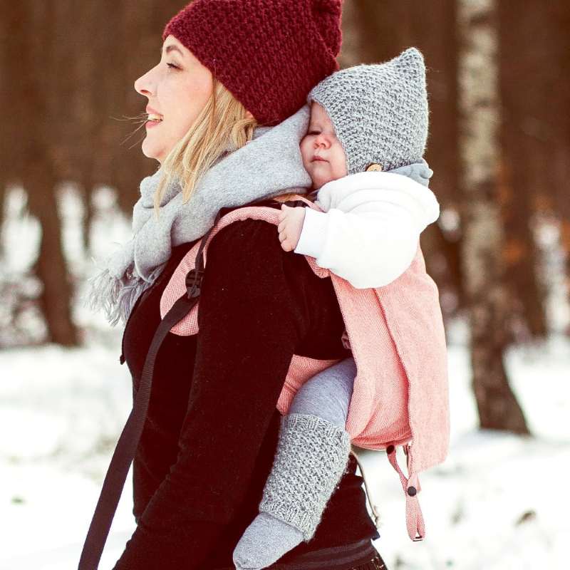 赤いおんぶ紐で赤ちゃんをおんぶする女性