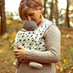 星柄のベビーラップで赤ちゃんを抱っこしてキスをするお母さん