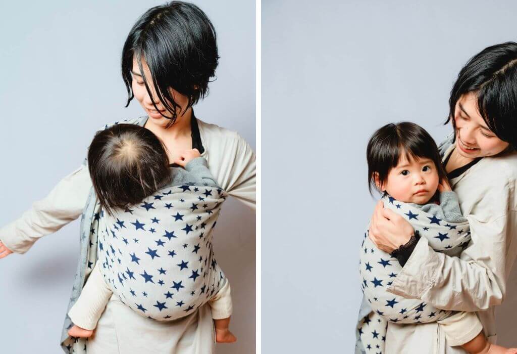 ストライプ柄のスリングで1歳の娘を抱っこするママ