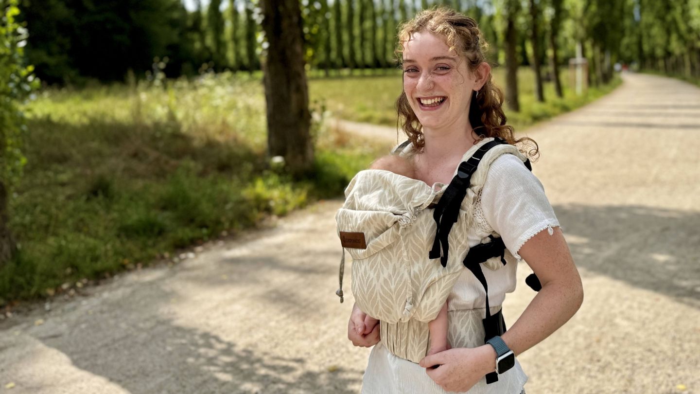 新生児を抱っこ紐で抱っこする小柄なママ