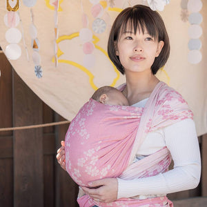 ベビーラップで新生児を抱っこする女性