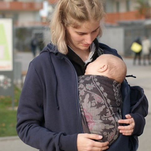 ピンクとグレーの花柄のベビーラップを装着しているママ