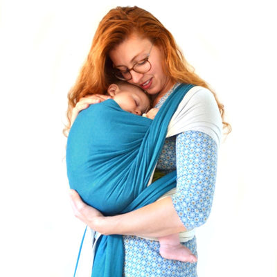 ターコイズブルーのストレッチラップで赤ちゃんを抱っこしている女性
