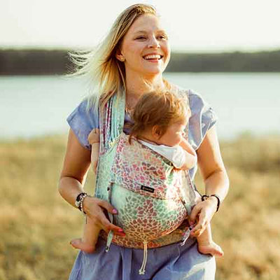抱っこ紐で赤ちゃんを抱っこして笑顔あふれるママ