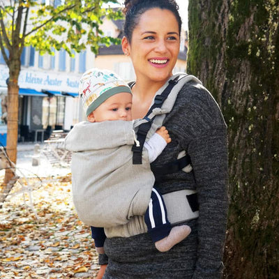 ニット帽をかぶった赤ちゃんを抱っこして笑っている女性