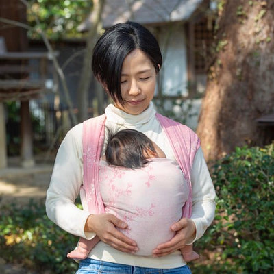 シルク混のベビーラップで赤ちゃんを抱く女性