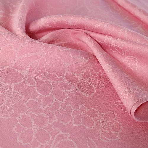 ピンク色にホワイトで描かれた桜模様の織物