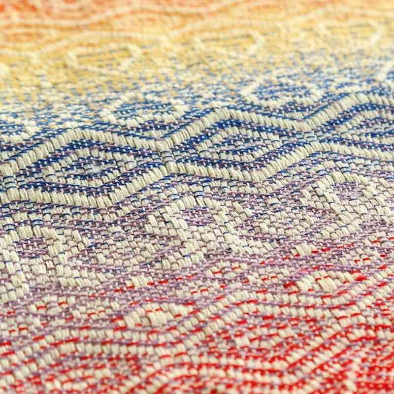 白、赤、紫、青、水色、黄色、橙色の糸で織られた布地