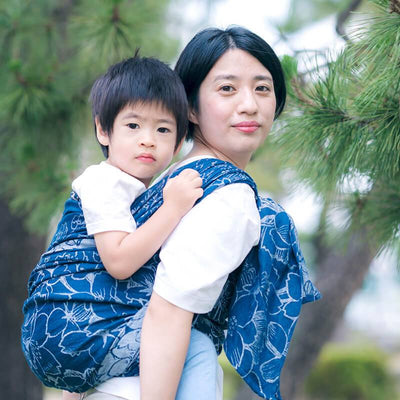 桜模様のブルーのベビーラップで男の子をおんぶしている日本人女性