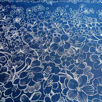 白い大小の白い花が舞うデザインのブルーの布地