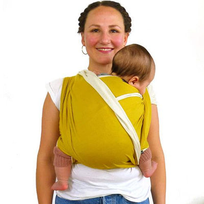 イエローのストレッチラップで赤ちゃんを抱っこしている黒髪の女性